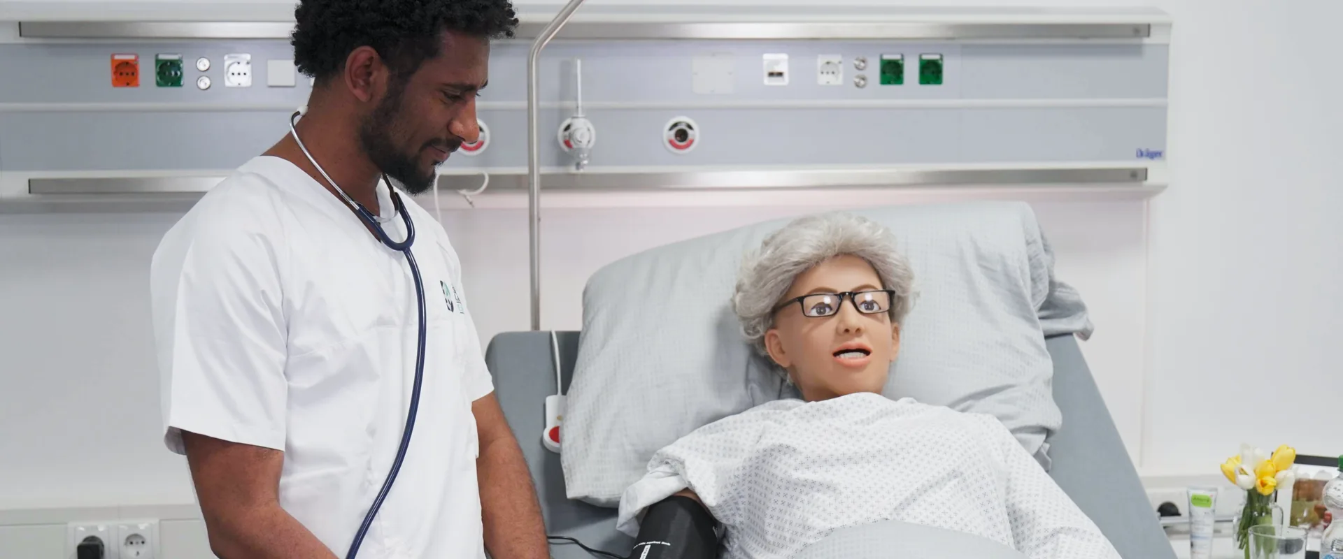 Pflegefachperson misst den Blutdruck an einer Simulationspuppe im Skills Lab